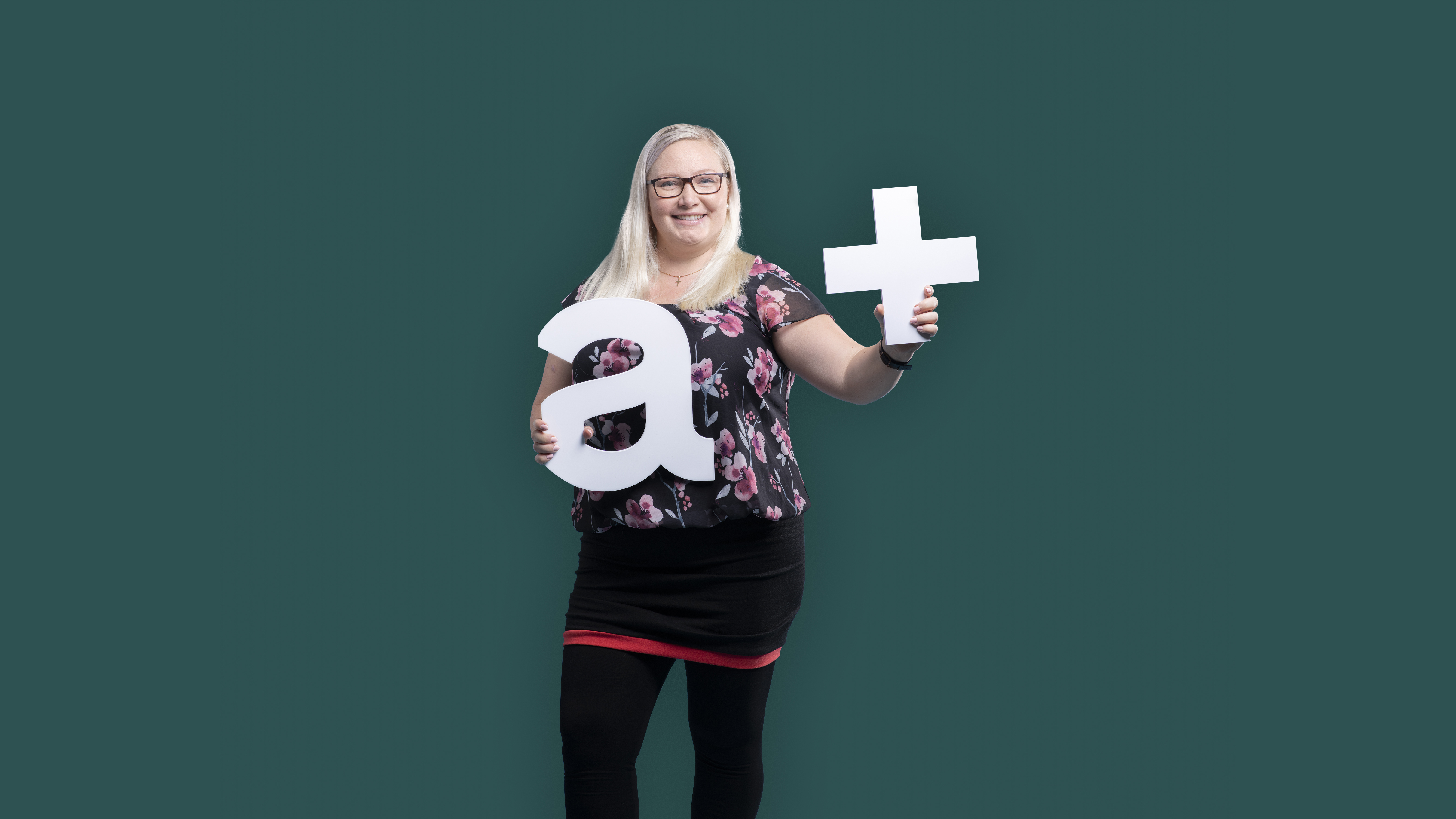 woman holding an a+ sign in green background