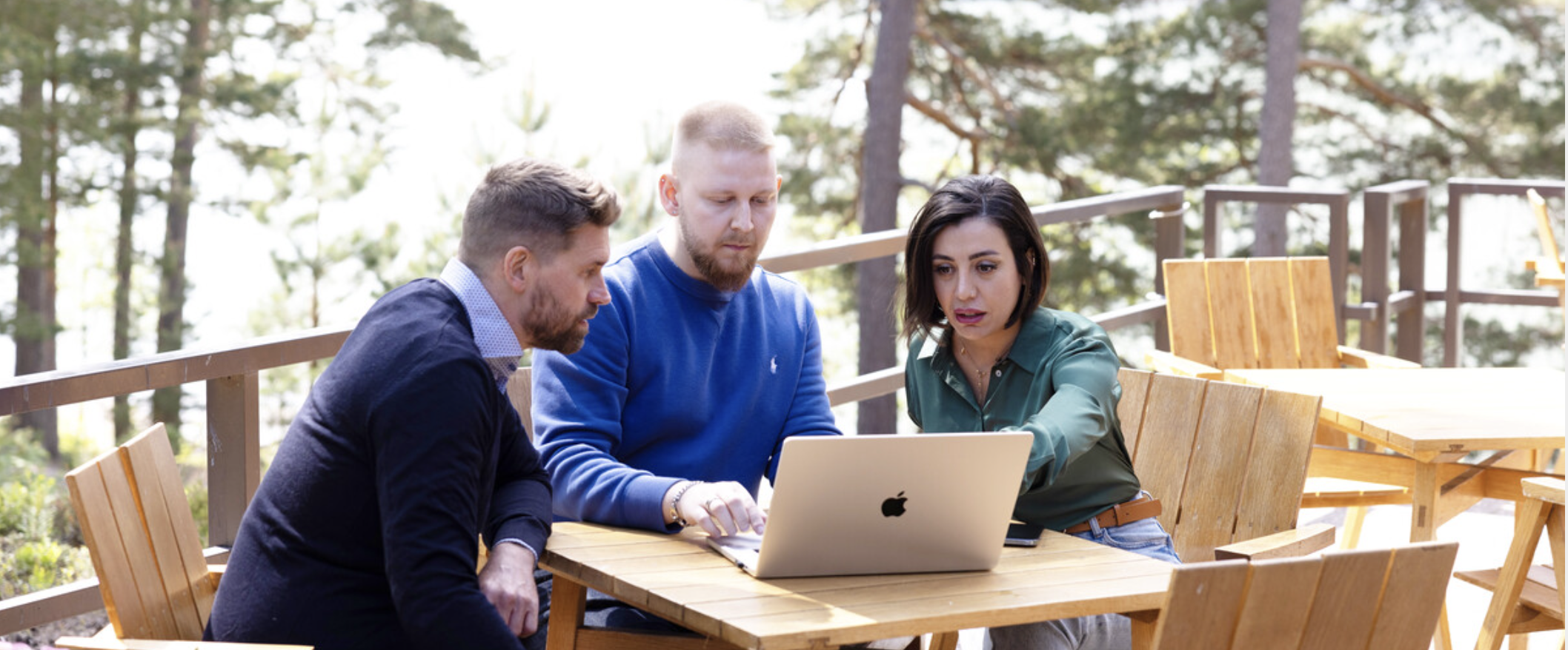 tre kolleger foran en pc