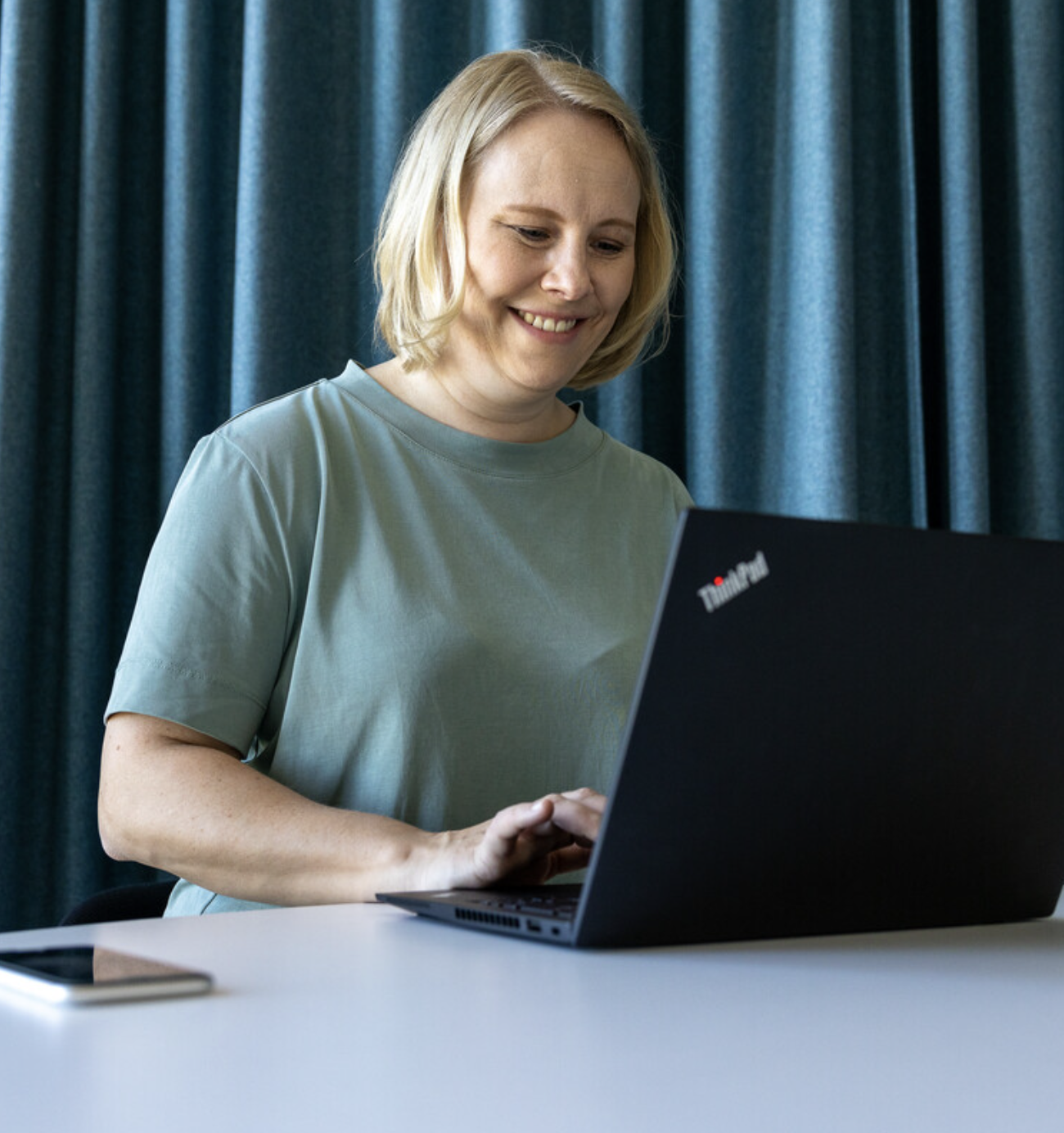Dame med laptop smiler