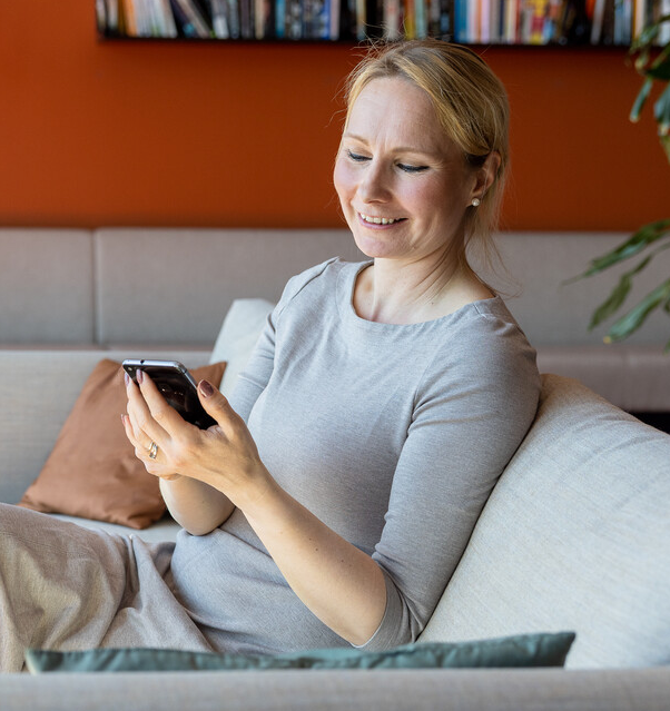 kvinne med telefon i sofa