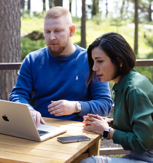 Kollegaer i skogen med laptop