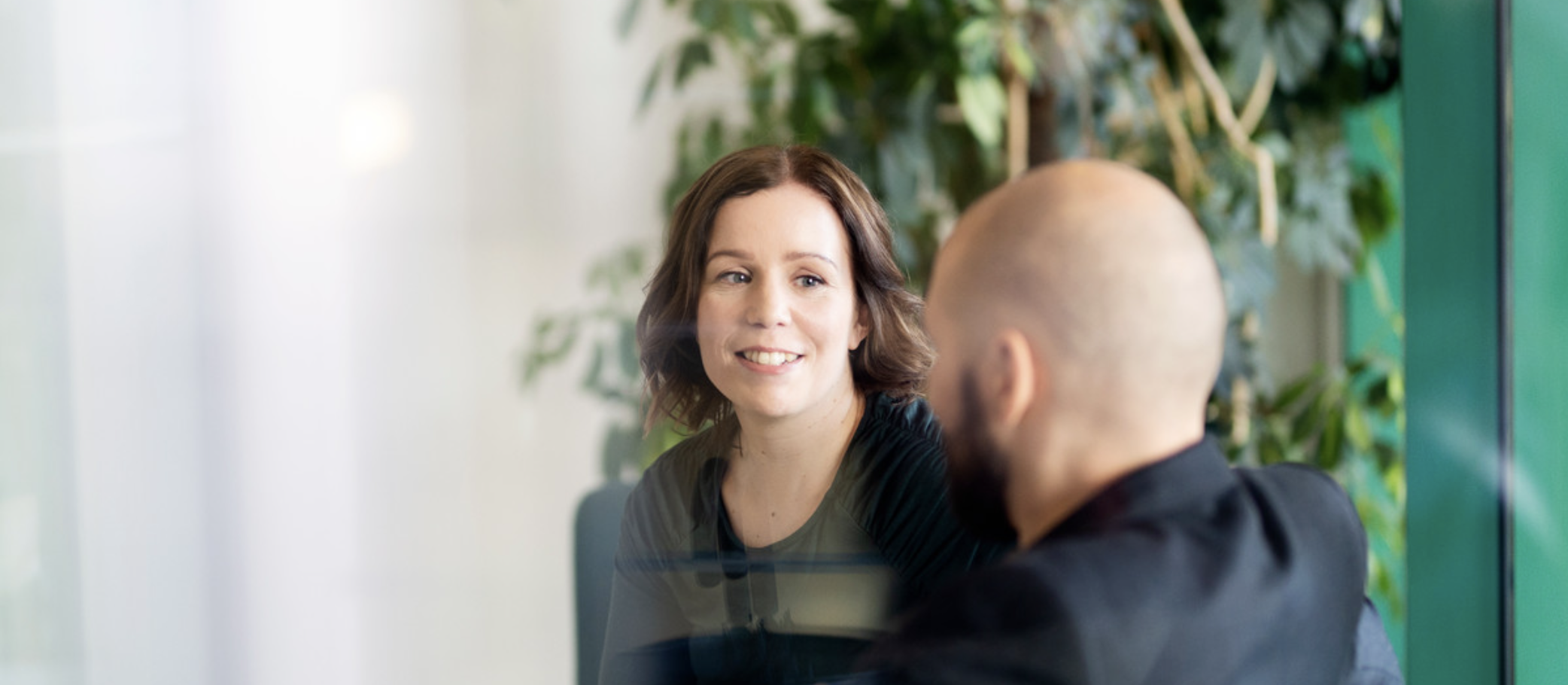 En mann og en kvinne som prater. Kvinnen ansikt er synlig og ser ut som hun lytter