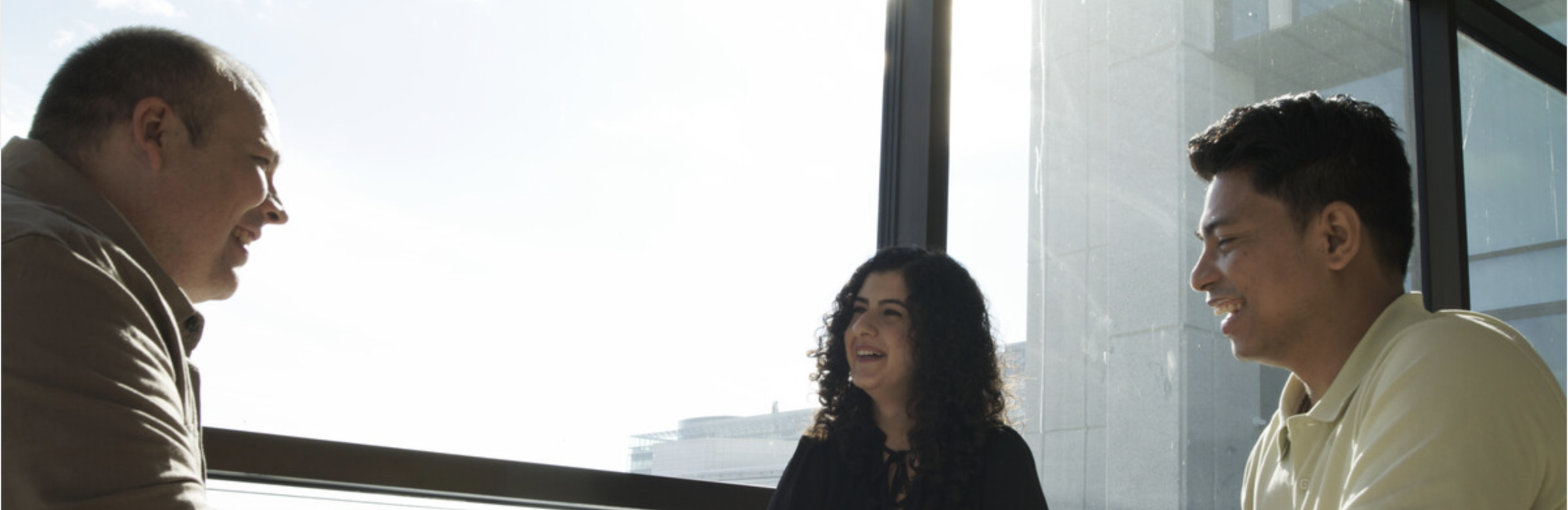 folk som prater i et kantineområde, smiler og ler. Det er fint vær