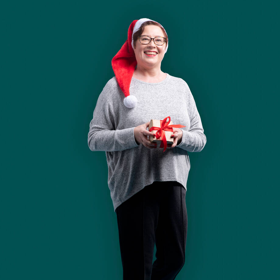 Työntekijä tonttulakki päässään ja joululahja käsissään