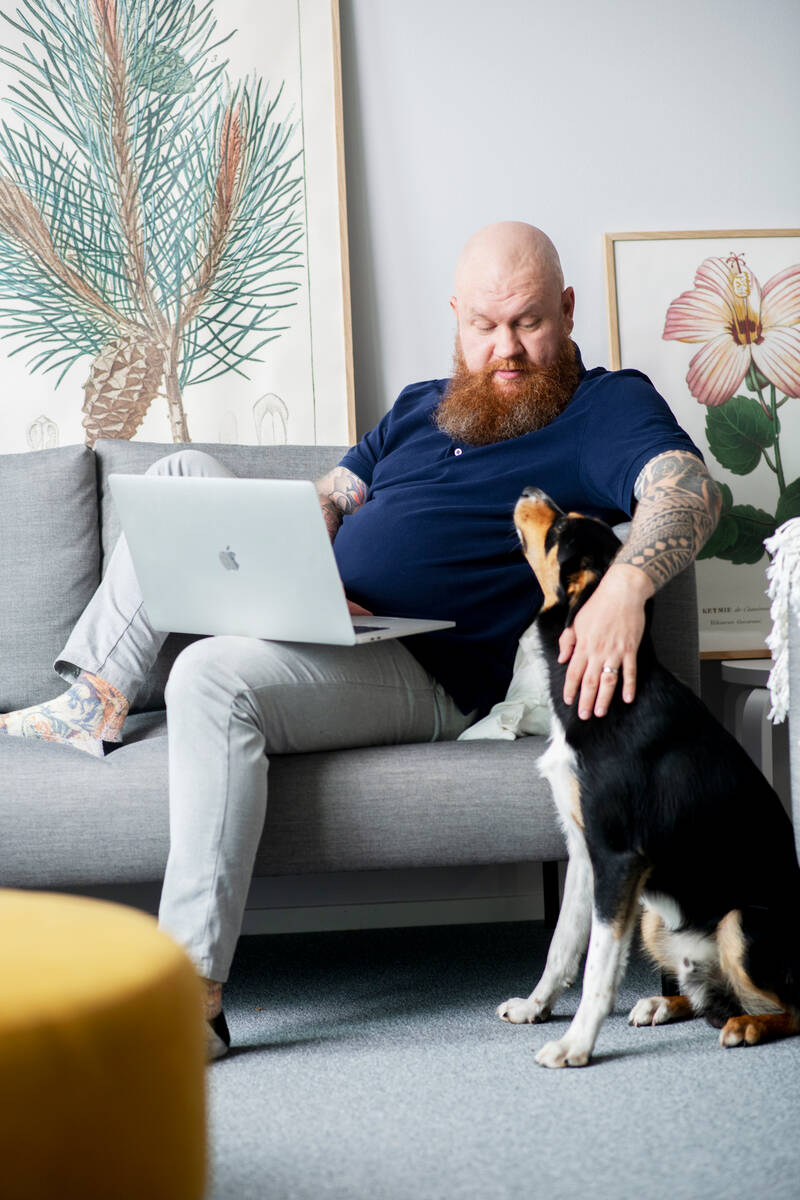 man on sofa patting a dog