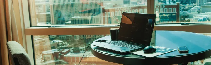 Pc på et bord på hotellrom med utsikt over en by