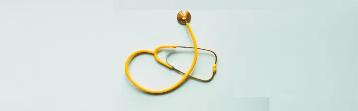 gult stetoskop på blå bakgrunn 