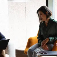 two women and man in a meeting discussion